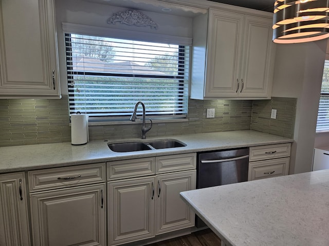 kitchen with backsplash, light stone countertops, sink, and stainless steel dishwasher