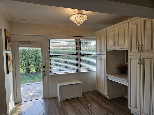 doorway featuring crown molding, dark wood-type flooring, and a chandelier