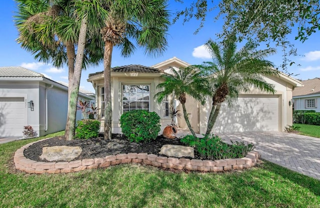 mediterranean / spanish-style house featuring a front yard and a garage