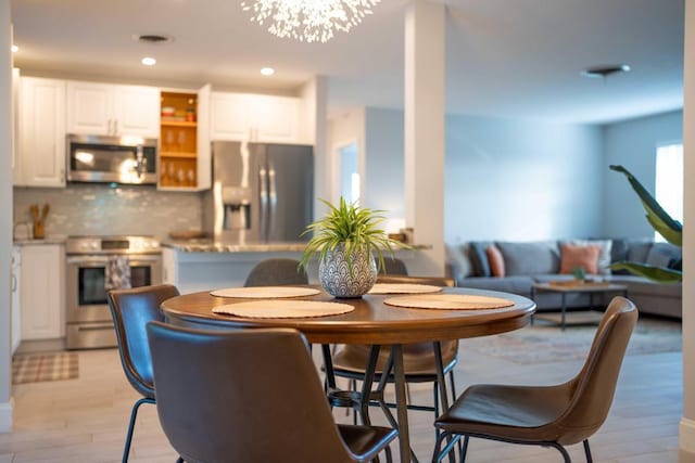 dining area featuring an inviting chandelier and light hardwood / wood-style flooring