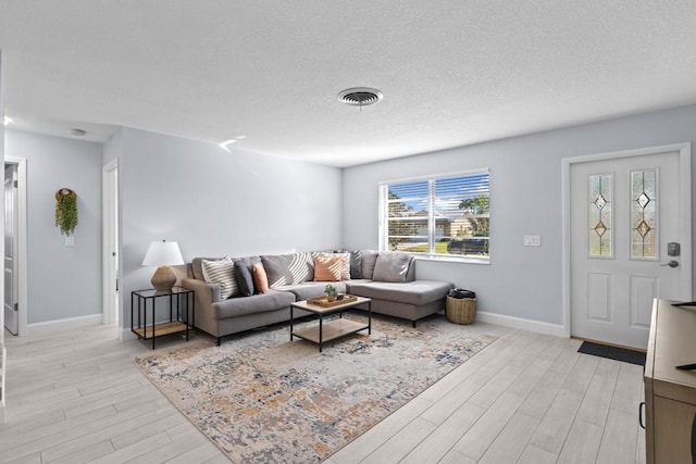 living room featuring light hardwood / wood-style floors and a textured ceiling