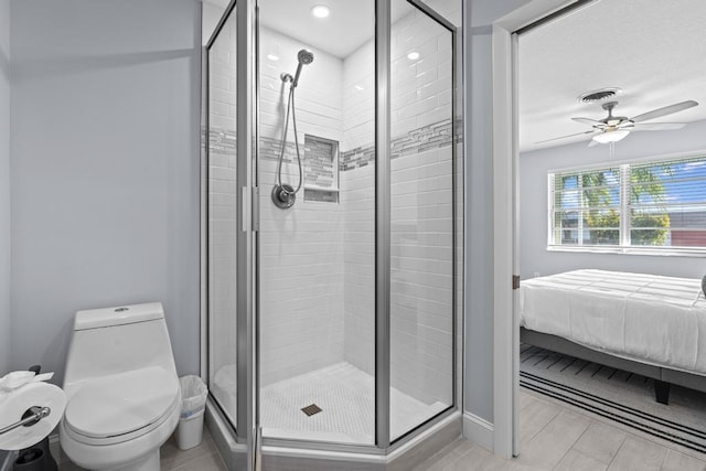 bathroom featuring ceiling fan, toilet, and walk in shower