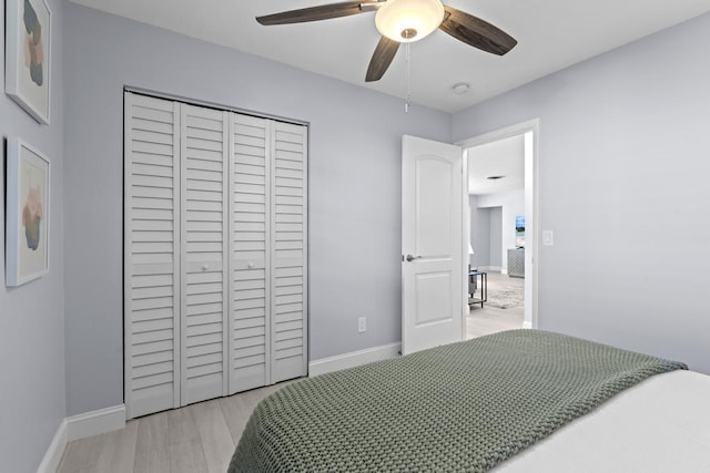 bedroom featuring ceiling fan, a closet, and light hardwood / wood-style flooring