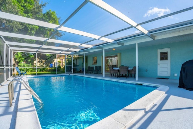 view of swimming pool featuring glass enclosure and a patio area