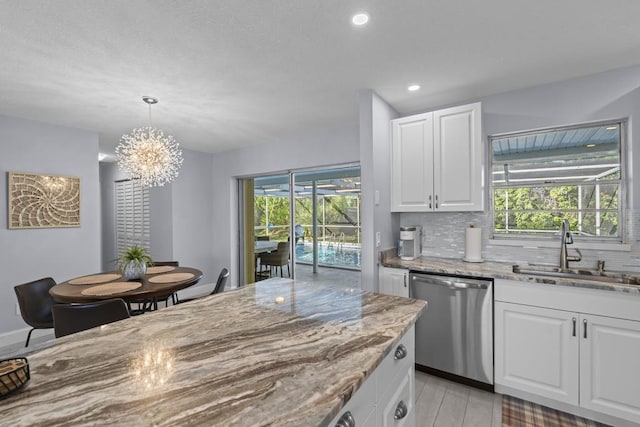 kitchen featuring stainless steel dishwasher, white cabinets, light stone countertops, and sink