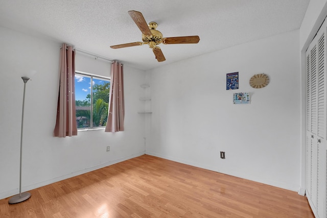 unfurnished bedroom with ceiling fan, a closet, a textured ceiling, and light hardwood / wood-style flooring