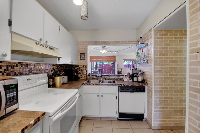 kitchen with brick wall, white appliances, ceiling fan, sink, and white cabinetry