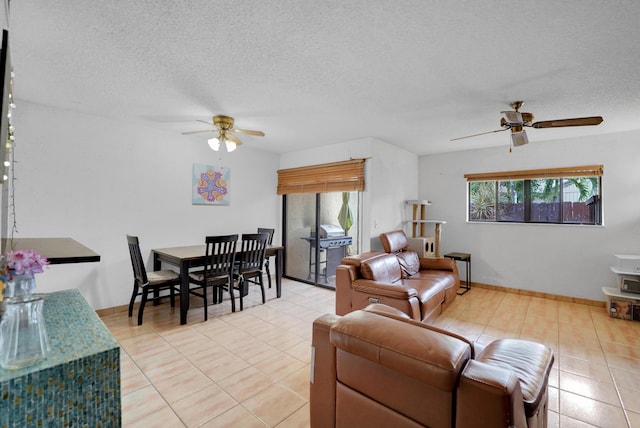 tiled living room featuring ceiling fan and a textured ceiling