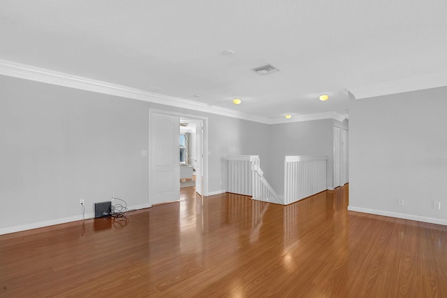 empty room with wood-type flooring and ornamental molding