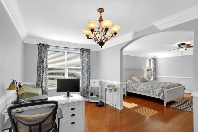 bedroom featuring dark hardwood / wood-style flooring, ceiling fan with notable chandelier, and ornamental molding