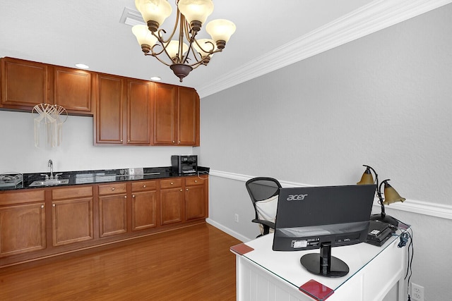 office featuring dark hardwood / wood-style flooring, ornamental molding, sink, and an inviting chandelier