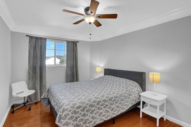 bedroom with hardwood / wood-style flooring, ceiling fan, and crown molding