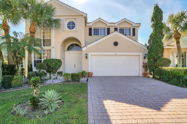 mediterranean / spanish house with a front yard and a garage