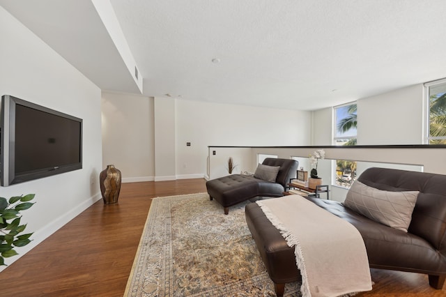 living room featuring dark hardwood / wood-style flooring and a textured ceiling