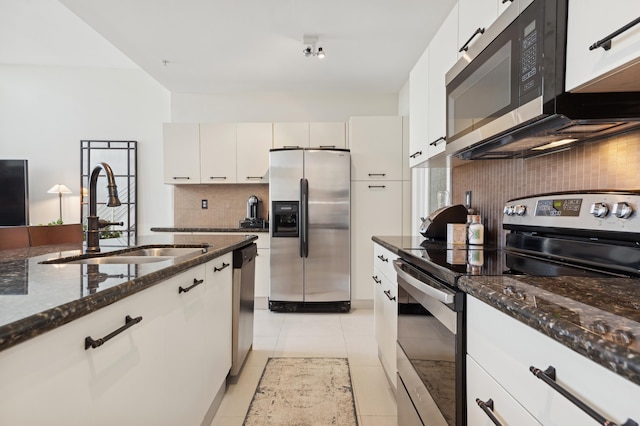 kitchen with decorative backsplash, stainless steel appliances, sink, white cabinetry, and light tile patterned flooring