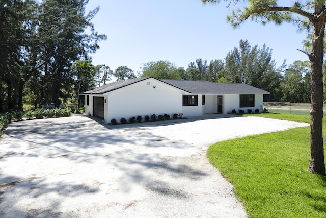 view of front of property with a front yard, driveway, and fence