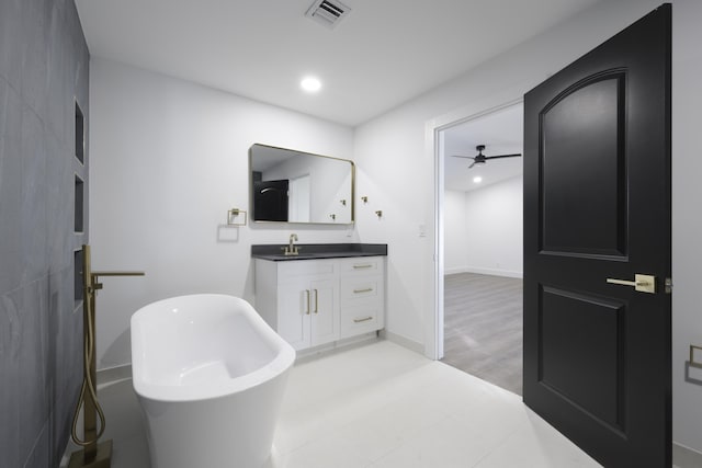 bathroom with a bathing tub, ceiling fan, hardwood / wood-style floors, and vanity