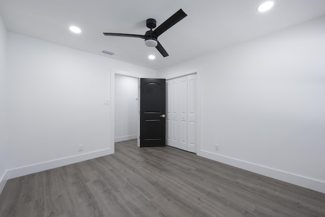 unfurnished bedroom featuring ceiling fan and dark hardwood / wood-style flooring