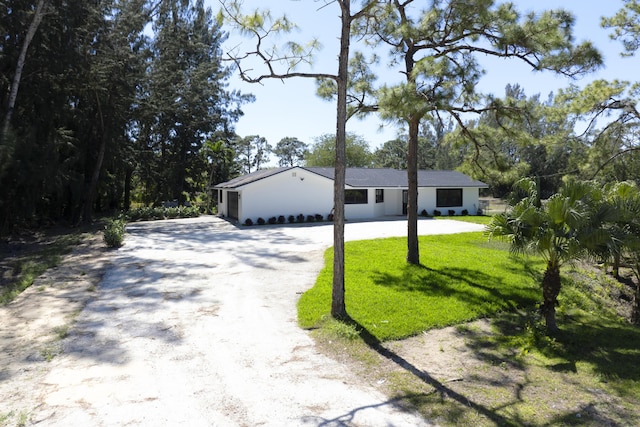 view of front of house featuring driveway and a front lawn