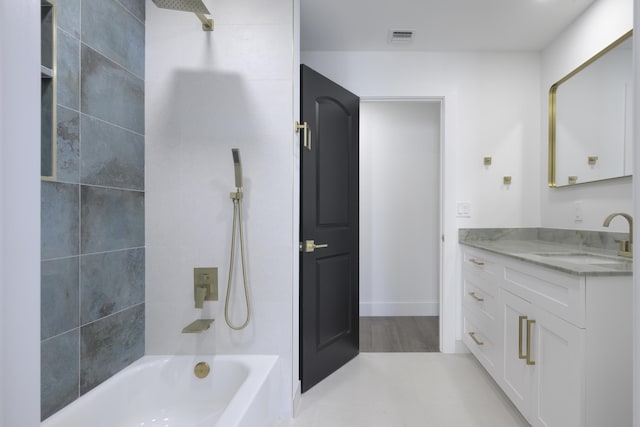 bathroom with vanity, tiled shower / bath combo, and hardwood / wood-style flooring