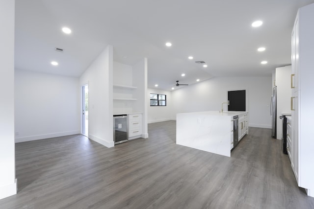 kitchen with vaulted ceiling, dark wood-type flooring, sink, white cabinets, and wine cooler