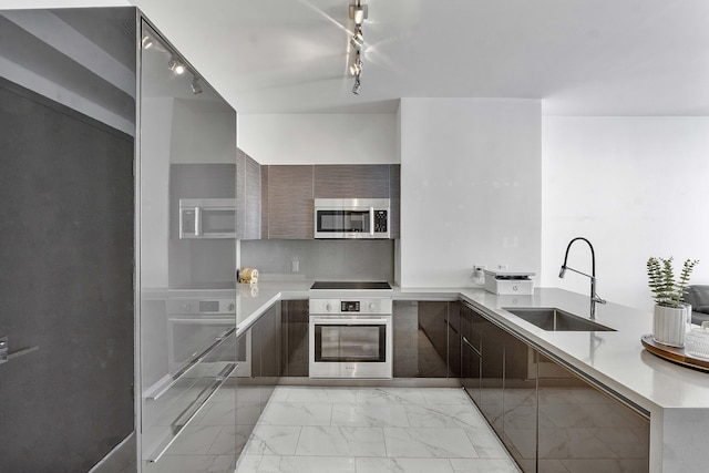 kitchen featuring sink, track lighting, and appliances with stainless steel finishes