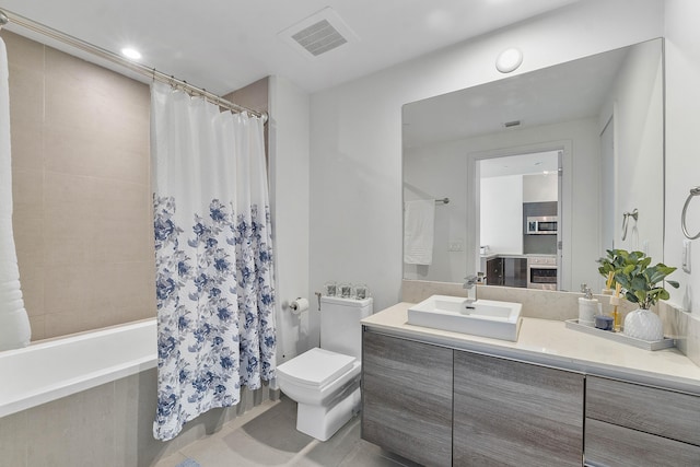 full bathroom featuring toilet, vanity, tile patterned floors, and shower / bath combo with shower curtain