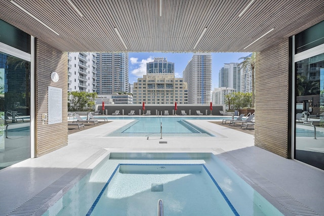 view of swimming pool with a community hot tub and a patio area