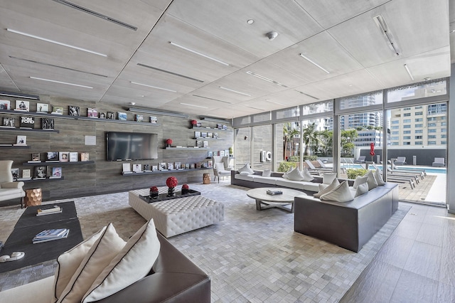 living room featuring floor to ceiling windows and wooden walls