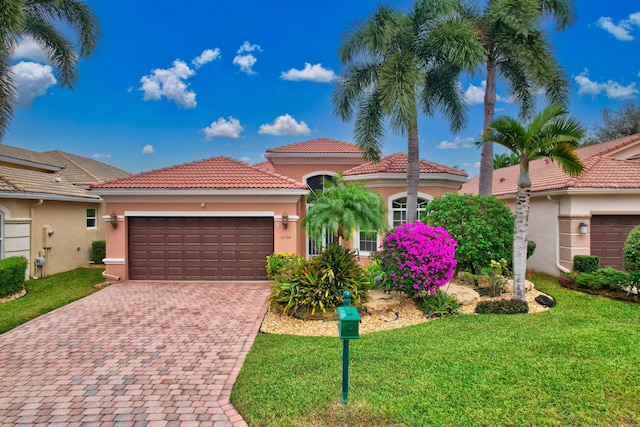 mediterranean / spanish-style home with a front yard and a garage