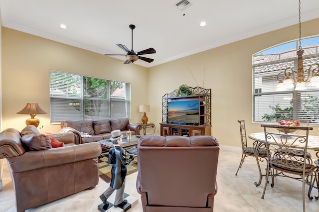 living room with light tile patterned floors, ceiling fan with notable chandelier, a wealth of natural light, and ornamental molding