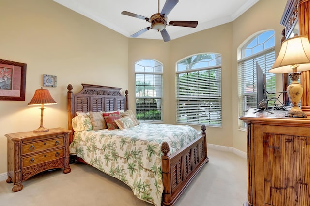 bedroom featuring ceiling fan, light colored carpet, crown molding, and multiple windows