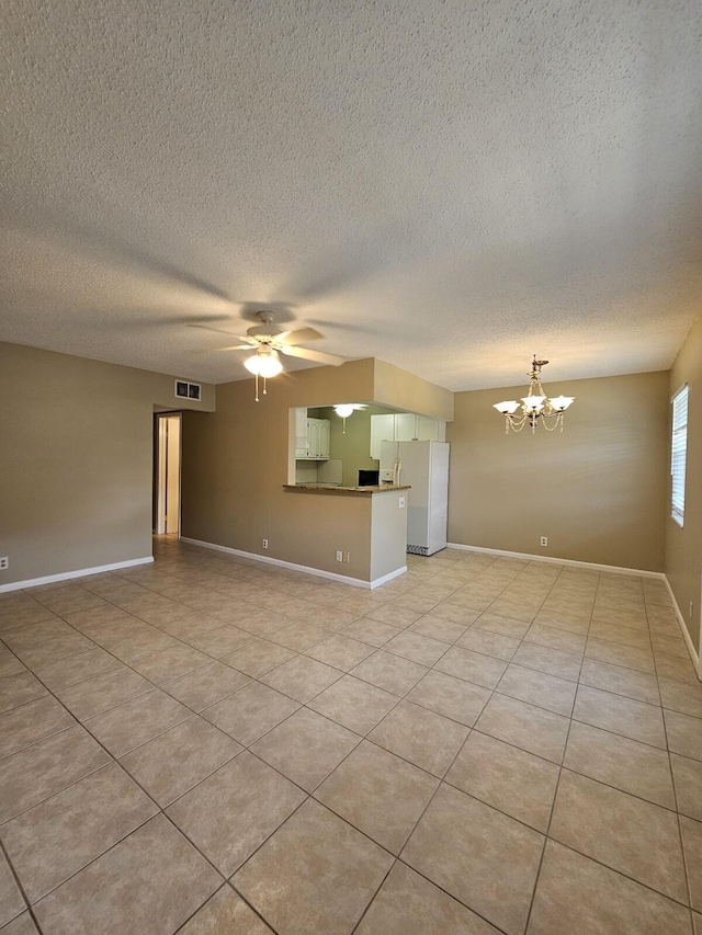 unfurnished living room with ceiling fan with notable chandelier, light tile patterned flooring, and a textured ceiling