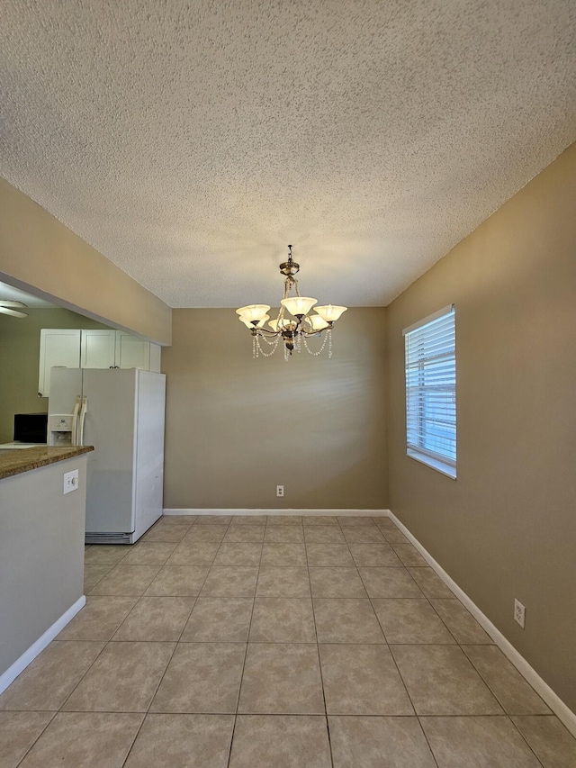 unfurnished dining area featuring light tile patterned floors, a chandelier, and a textured ceiling