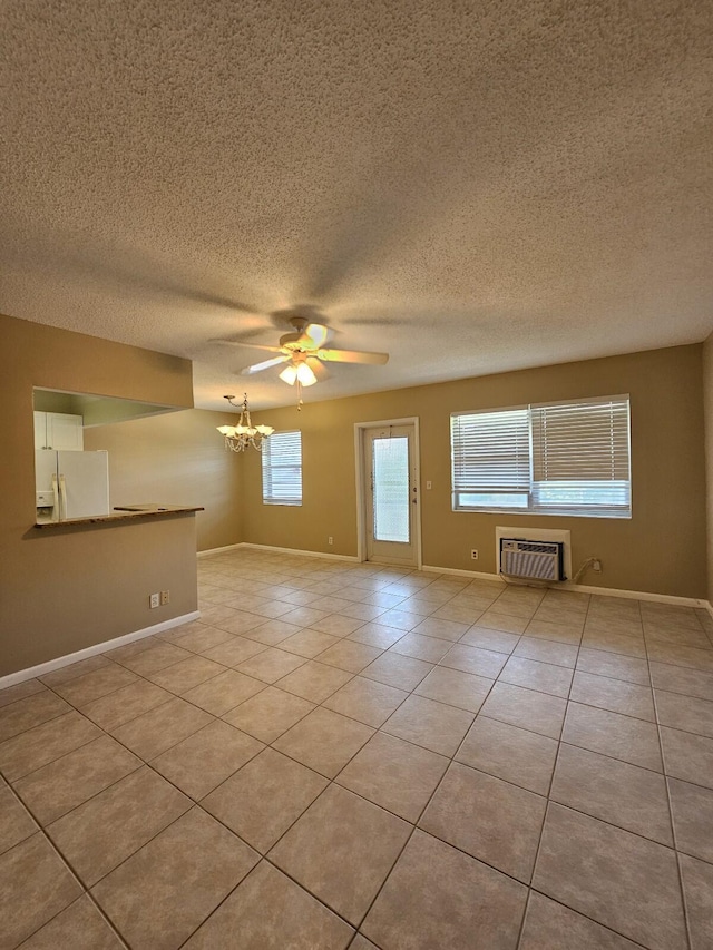 tiled spare room featuring a wall mounted air conditioner, a textured ceiling, and ceiling fan with notable chandelier