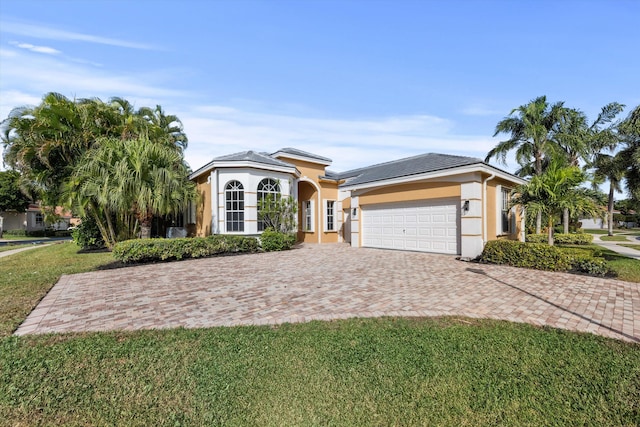 view of front of house featuring a garage and a front lawn