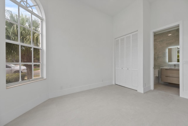 unfurnished bedroom featuring a closet and ensuite bath