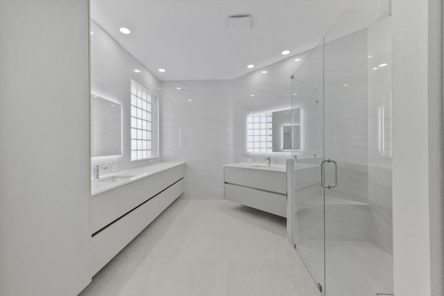 bathroom with plenty of natural light, a shower with door, and vanity