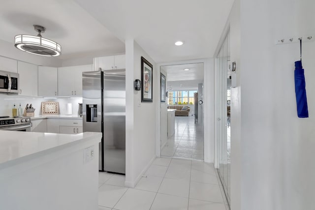 kitchen featuring white cabinets, light tile patterned flooring, and appliances with stainless steel finishes