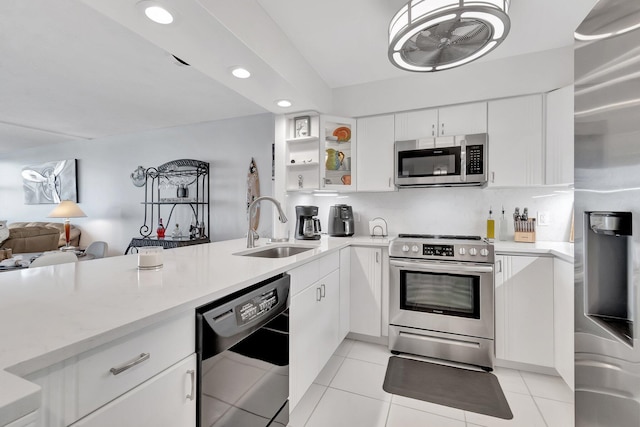 kitchen featuring sink, light tile patterned floors, backsplash, white cabinets, and appliances with stainless steel finishes