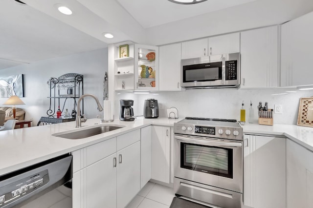 kitchen with white cabinets, light tile patterned flooring, sink, and stainless steel appliances