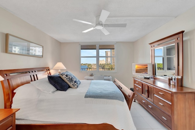 bedroom featuring a textured ceiling, multiple windows, and ceiling fan