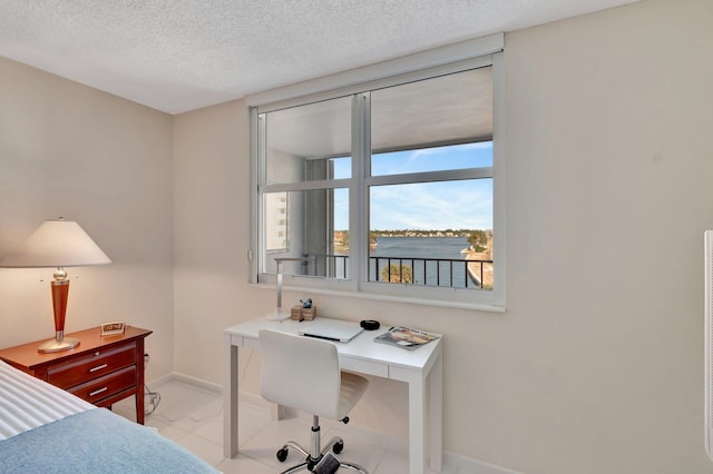 bedroom featuring a textured ceiling, a water view, and floor to ceiling windows