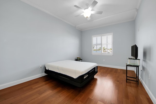 bedroom featuring ceiling fan, dark hardwood / wood-style floors, and ornamental molding