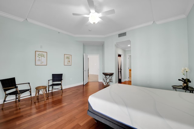 bedroom featuring ceiling fan, wood-type flooring, and ornamental molding