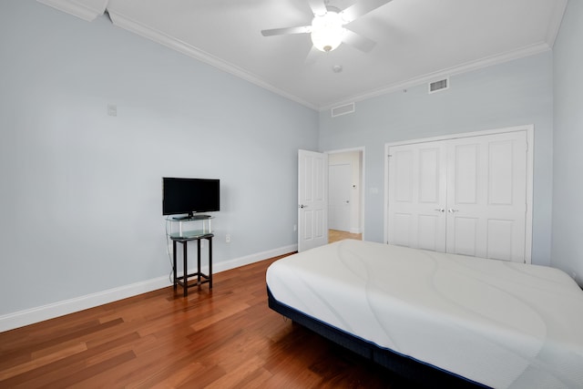 bedroom featuring a closet, ceiling fan, crown molding, and wood-type flooring