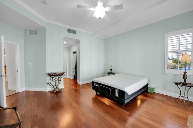 bedroom featuring wood-type flooring, ceiling fan, and ornamental molding