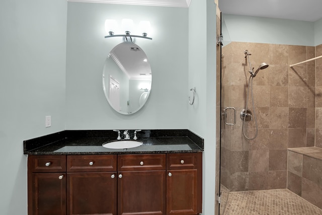 bathroom with a shower with door, vanity, and ornamental molding