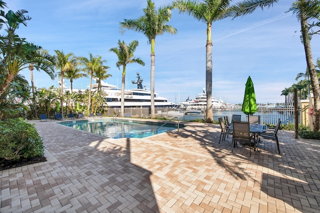 view of swimming pool with a patio and a water view