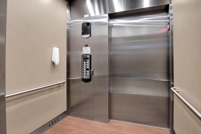 details featuring elevator and wood-type flooring